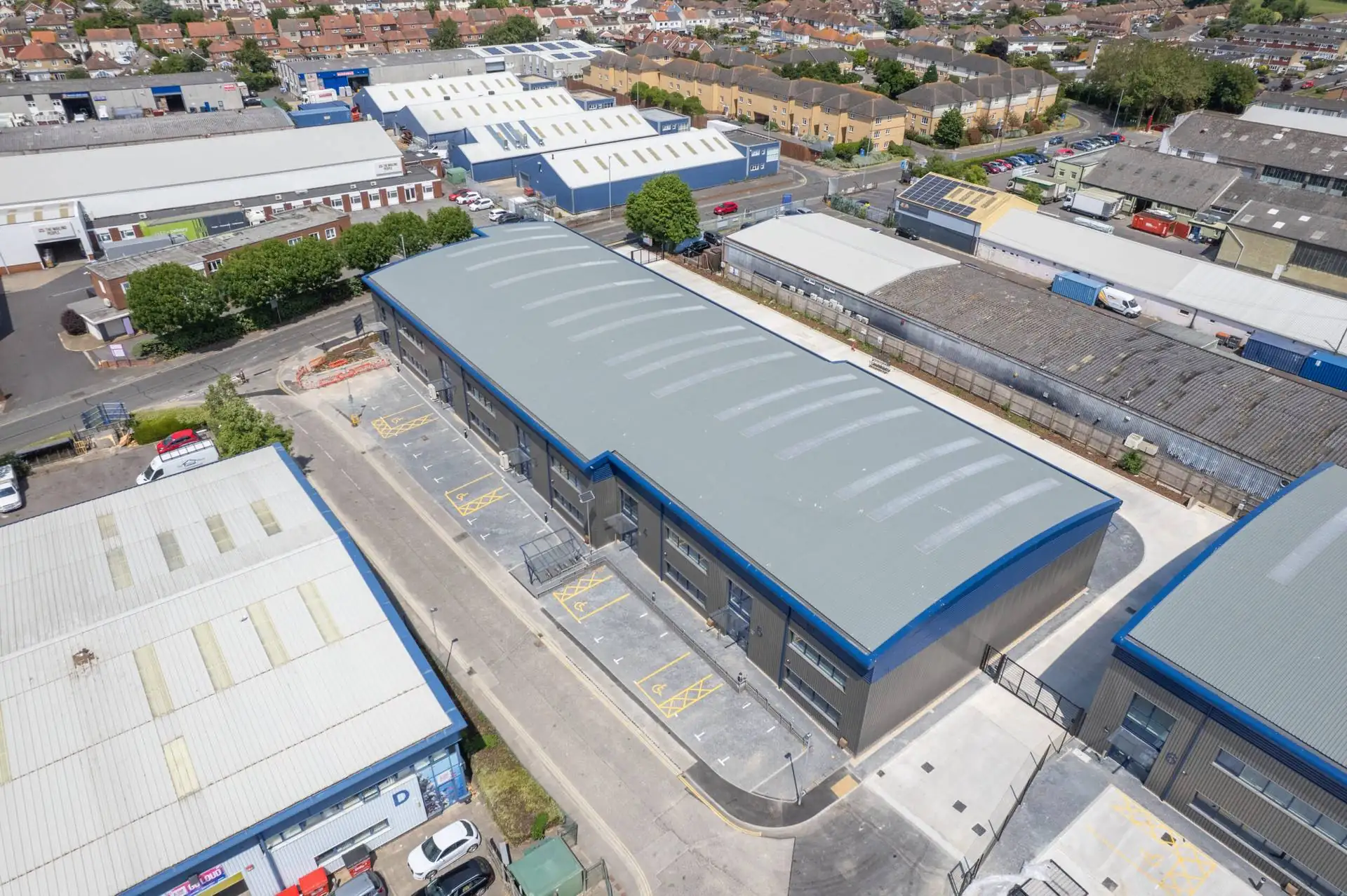 Aerial view of modern industrial units with curved roofs on a commercial estate