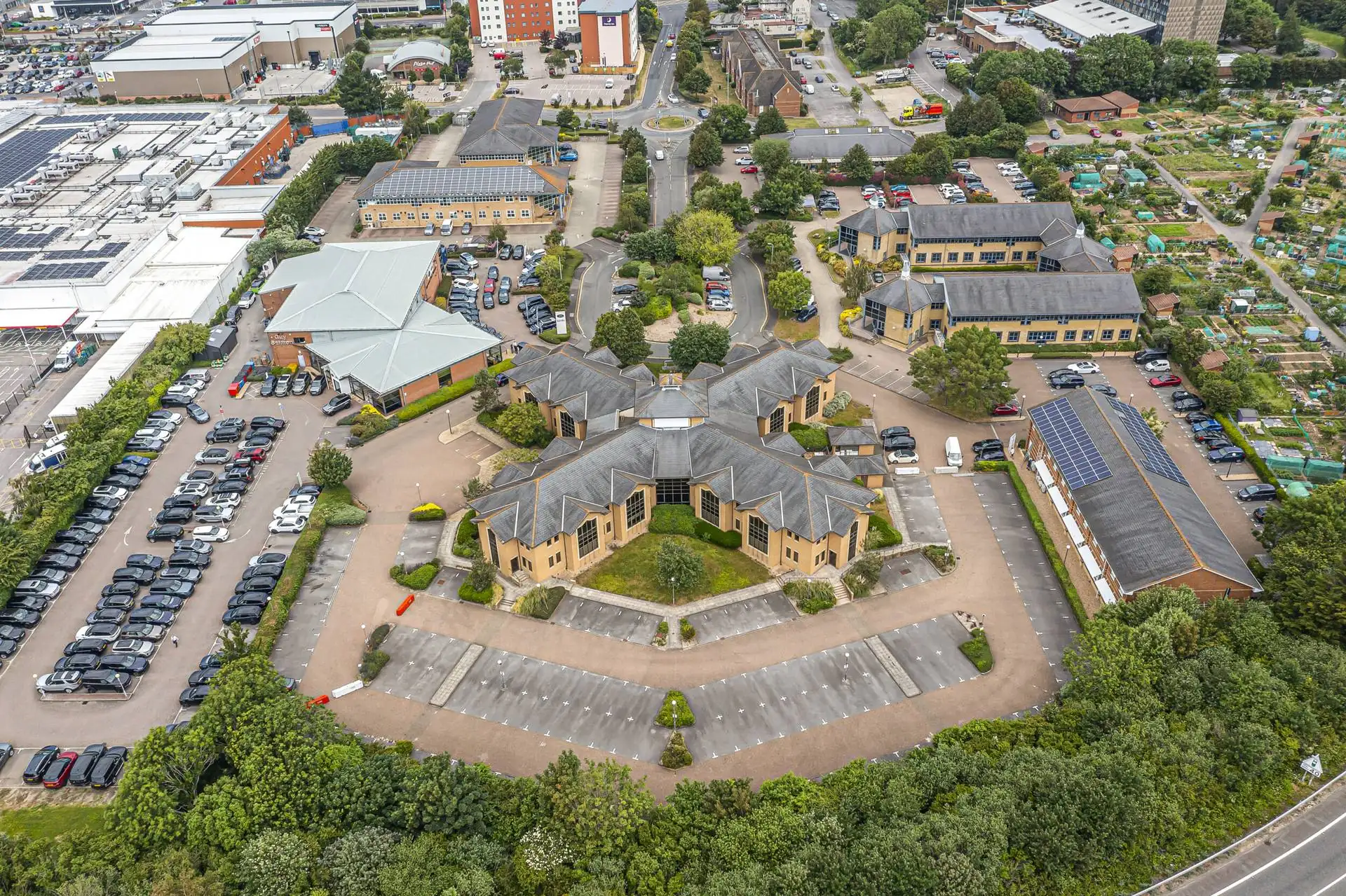 Aerial view of a landscaped business park with office buildings and car parks