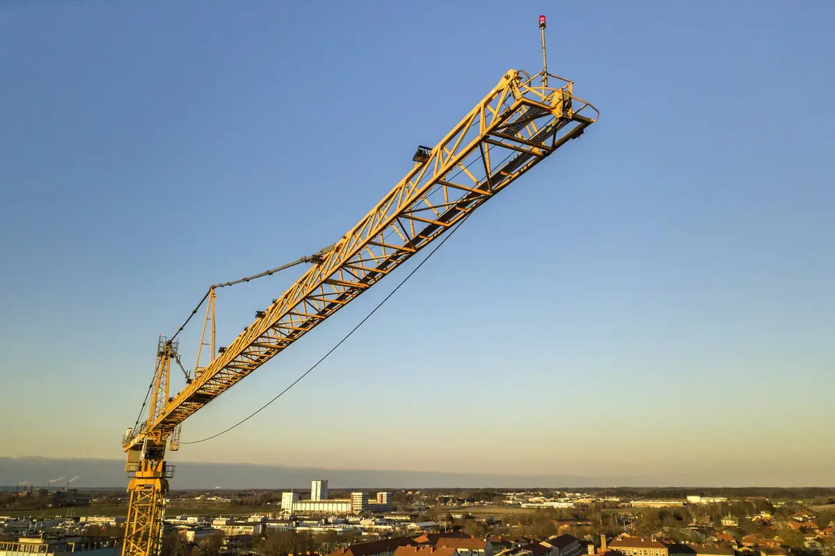 Tower crane against a clear evening sky above a town