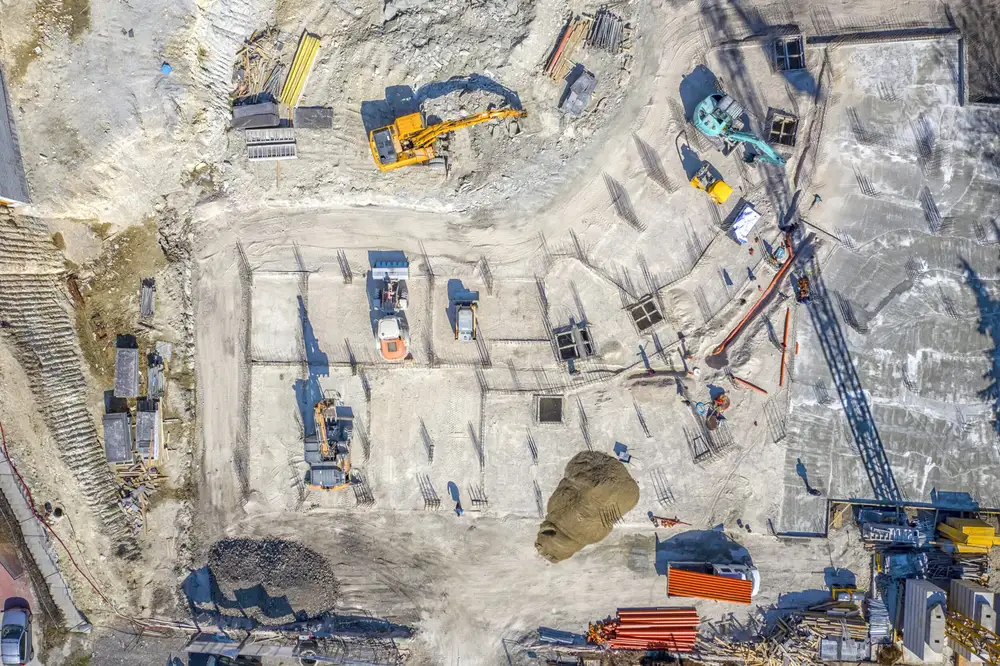Aerial view of a construction site with excavators and cleared ground