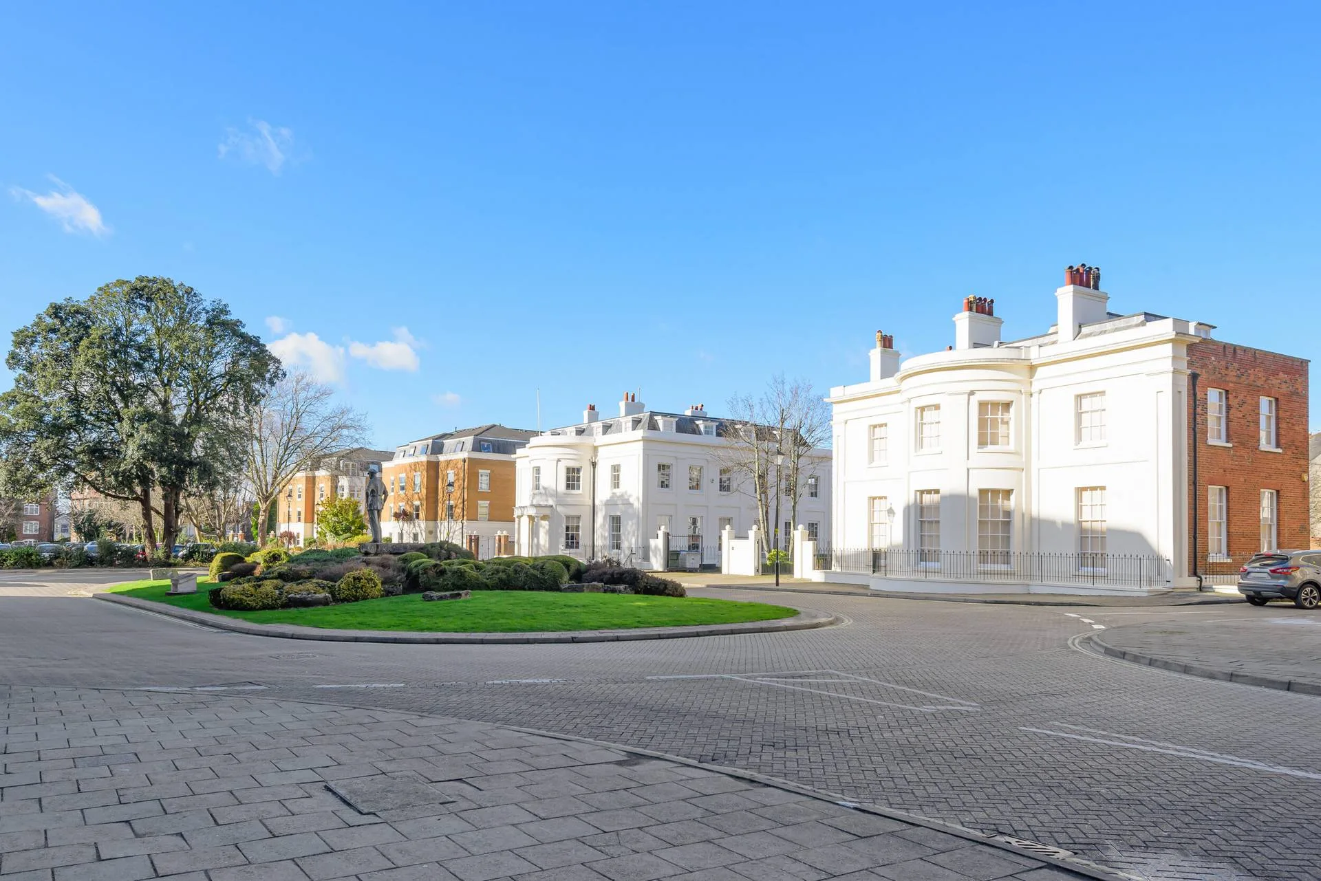 White Georgian commercial building beside a landscaped roundabout