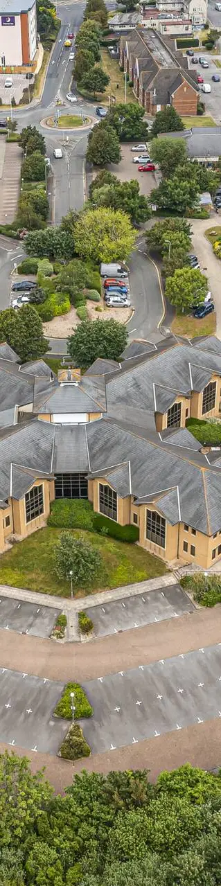 Aerial view of a business park with office buildings, car parks and trees
